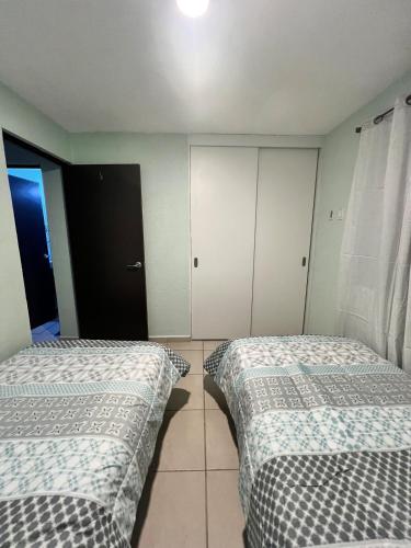 a bedroom with two beds and a closet at Smart Home en Tlajomulco de Zúñiga in Santa Cruz de las Flores
