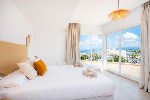 a bedroom with a large white bed and a large window at Villa Son Veri de la Marina in El Arenal