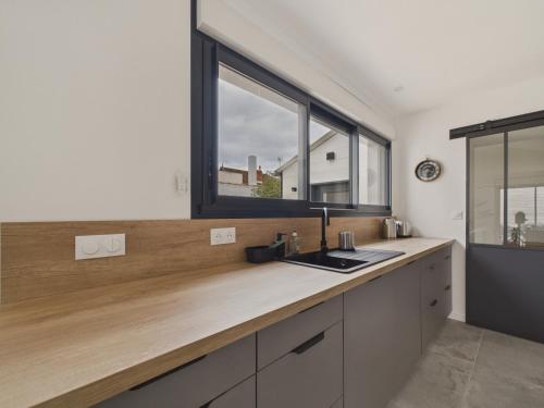 une cuisine avec un évier et une fenêtre dans l'établissement Jolie maison moderne - jacuzzi - terrasse pour 4, à Saint-Gilles-Croix-de-Vie
