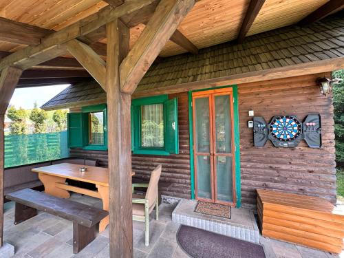 Una cabaña de madera con una mesa y un tablero de dardos encima. en Hestur Ivo, en Izvoare