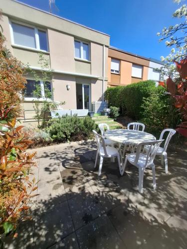 a patio with a table and chairs in front of a building at Charmante maison familiale in Rixheim