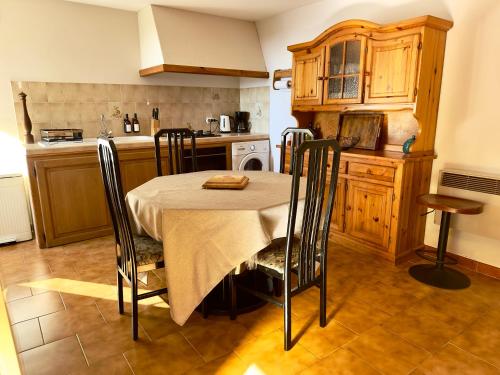 une cuisine avec une table et des chaises dans une cuisine dans l'établissement Location de vacances, 3 chambres, Canari, à Canari