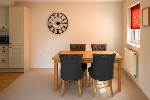 a dining room table with chairs and a clock on the wall at Elegant 2BD Townhouse in Thirsk: Cozy & Stylish in Thirsk