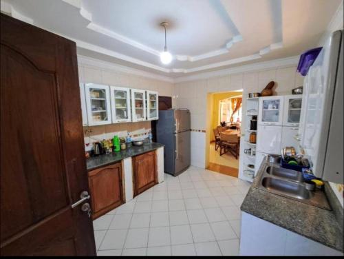 una cocina con fregadero y refrigerador en Villa Jane in Arusha, en Arusha