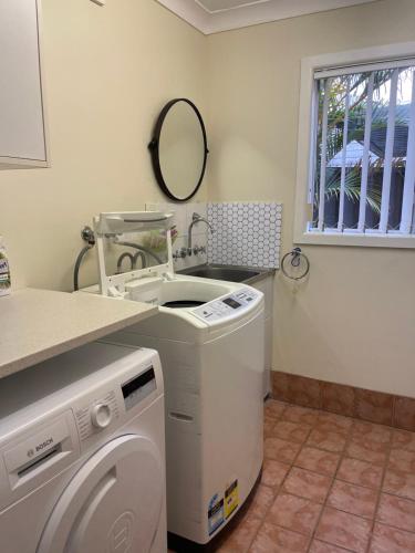 a laundry room with a washing machine and a sink at Garden View Entire Self Contained Guesthouse in Engadine