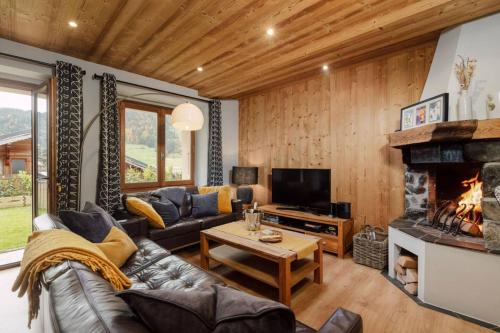 a living room with a couch and a fireplace at Stylish 3-bed Apartment With Jacuzzi Central Mor in Morzine