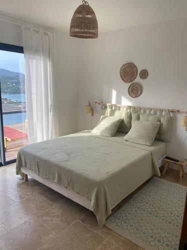 une chambre avec un grand lit avec une grande fenêtre dans l'établissement Villa with sea and mountain views, à Conca