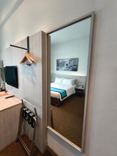 a hotel room with a bed and a mirror at Alamis City Kuala Lumpur - Formerly EDC Hotel Kuala Lumpur in Kuala Lumpur