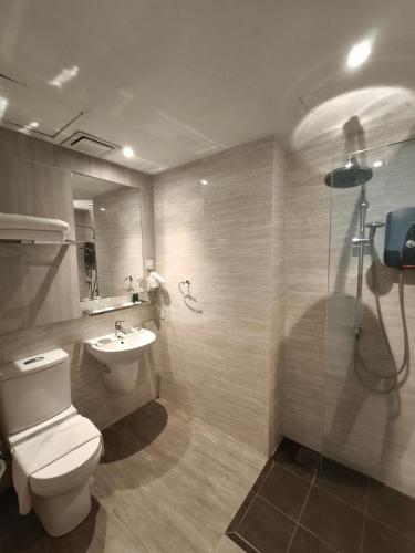 a bathroom with a toilet and a sink and a shower at Alamis City Kuala Lumpur - Formerly EDC Hotel Kuala Lumpur in Kuala Lumpur