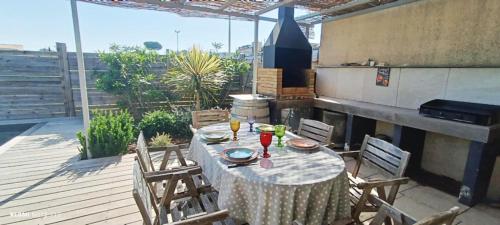 a table with chairs and drinks on a patio at Villa avec piscine - 3 chambres in Alignan-du-Vent