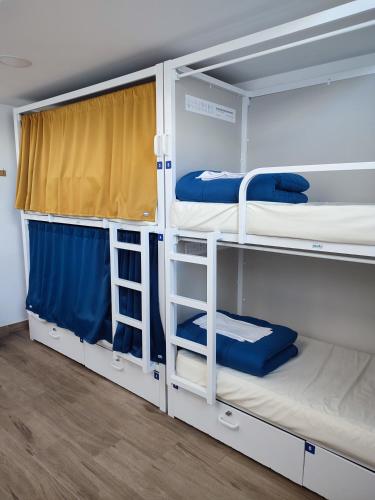 two bunk beds in a room with a window at Albergue SP 55 by Bossh! Hotels in Santiago de Compostela