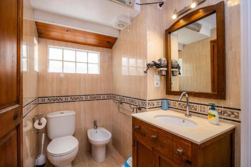 a bathroom with a toilet and a sink and a mirror at Eliasneil in Andratx