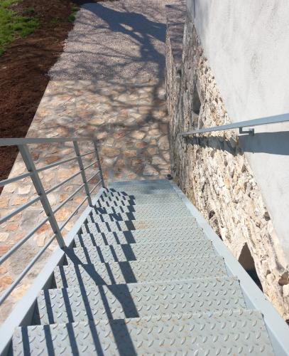 a staircase leading up to a wall with a metal railing at Apartment 2323 in Foli