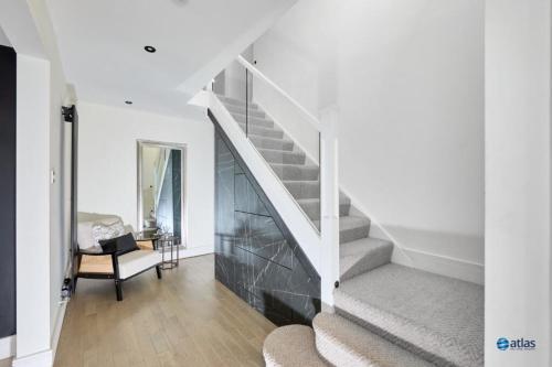 a white staircase in a living room with a chair at Large NEW Detached House Woolton, Families, FREE Parking, Massage, BBQ, Play room & MORE in Woolton