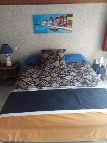 une chambre avec un lit avec un tableau sur le mur dans l'établissement Chambre d hôte, à La Celle-sous-Gouzon