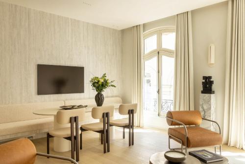 a living room with a table and chairs at Rive 15 - Appartements Parisiens in Paris