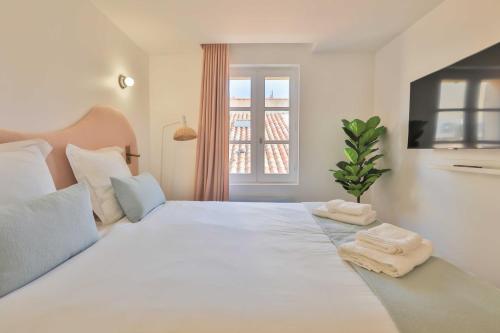 sypialnia z dużym białym łóżkiem z ręcznikami w obiekcie Nice 2 bed flat - Hyper centre St Tropez w Saint-Tropez
