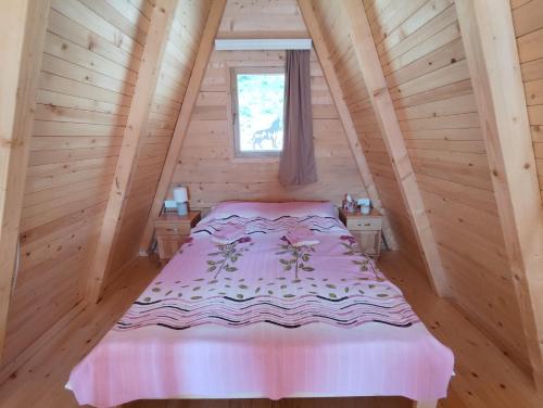 a bedroom with a bed in a wooden cabin at Sunčani Brijeg Eco Village in Plav