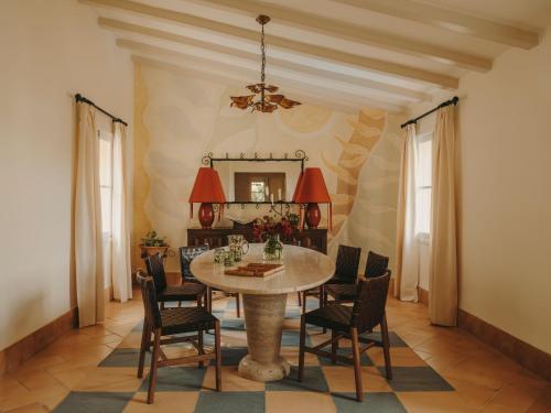 a dining room with a table and chairs and a mirror at La Residencia, A Belmond Hotel, Mallorca in Deia