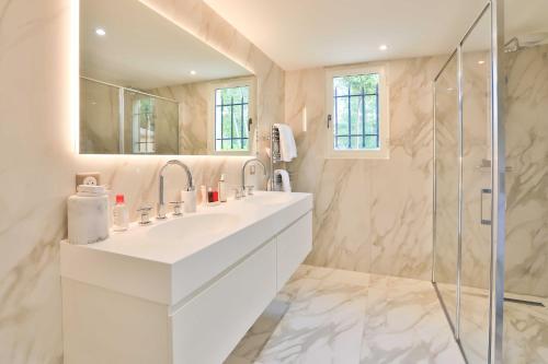 une salle de bain avec un lavabo blanc et une douche dans l'établissement Sumptuous Villa facing the Bay of Canebiers, à Saint-Tropez