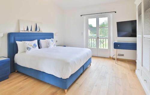 une chambre avec un lit bleu et une télévision dans l'établissement Sumptuous Villa facing the Bay of Canebiers, à Saint-Tropez