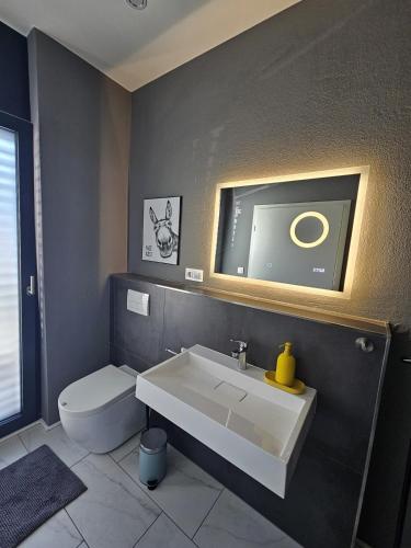 a bathroom with a white sink and a toilet at Traumwohnung mit Sauna Balkon in Bad Berleburg
