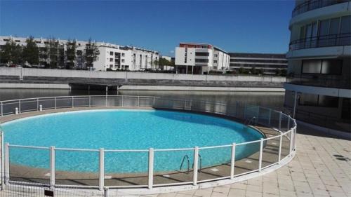 une grande piscine bleue à côté d'un immeuble dans l'établissement Appartement 2 pièces La Rochelle - LR030-B11, à La Rochelle
