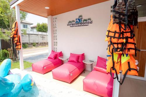 a patio with pink couches and a inflatable at Ongsa Poolvilla At Udonthani in Ban Dong Saphang