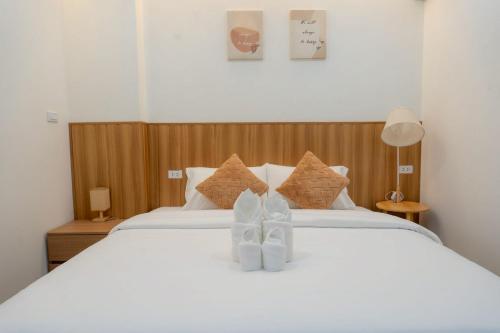 a bedroom with a white bed with two shoes on it at Ongsa Poolvilla At Udonthani in Ban Dong Saphang