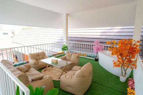 a balcony with couches and a table and flowers at Ongsa Poolvilla At Udonthani in Ban Dong Saphang