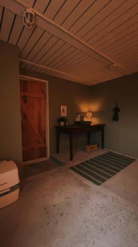 a room with a wooden ceiling and a table and a door at Granngården in Fåborg