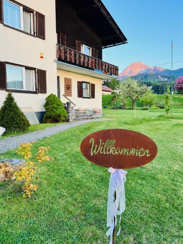 a sign in the grass in front of a building at Ferienhaus Faaker See 23 in Faak am See