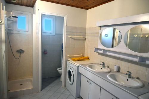a bathroom with two sinks and a washing machine at Paradis Provencal Le Calme total, Grande Piscine et Jacuzzi Chauffé, Salle de Jeux et Fresque du Nougat, Intimité in Montélimar