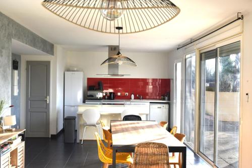 a kitchen with a table and a kitchen with red walls at Paradis Provencal Le Calme total, Grande Piscine et Jacuzzi Chauffé, Salle de Jeux et Fresque du Nougat, Intimité in Montélimar
