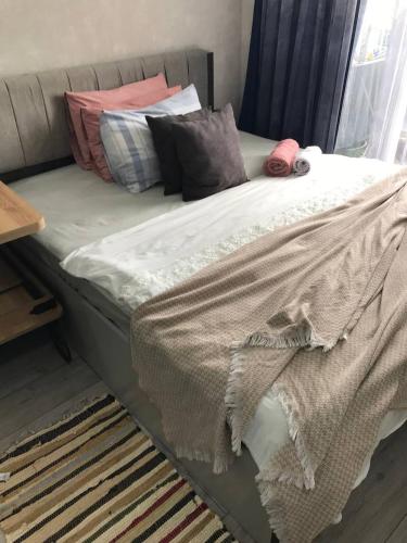 a bed with pillows and a blanket on it at Апартаменты с видом на море in Batumi