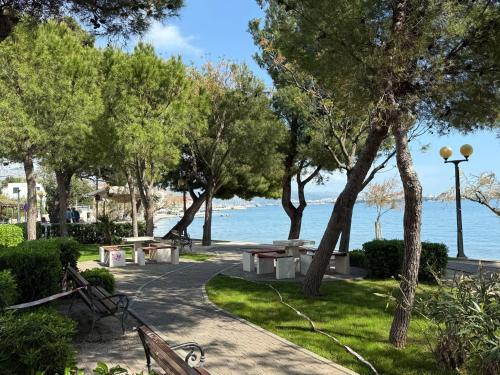 ein Park mit Bänken und Blick aufs Wasser in der Unterkunft Mili Minihouse in Kaštela