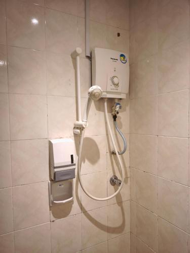 a shower in a bathroom with a hose on a wall at Alamis City Kuala Lumpur - Formerly EDC Hotel Kuala Lumpur in Kuala Lumpur