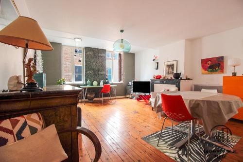 un salon avec une table et des chaises rouges dans l'établissement Lamarque, à Albi
