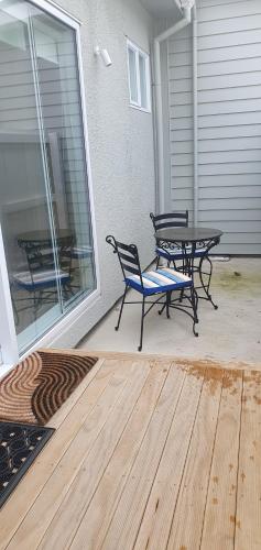 a patio with two chairs and a table on a porch at Arbor Suite in Greytown