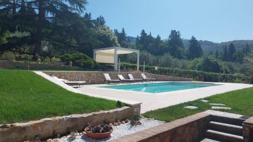 a swimming pool in a yard with chairs and a gazebo at Villa Salviati in Prato