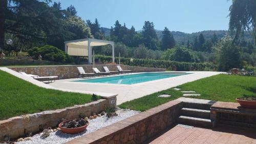 a swimming pool in a yard with lounge chairs at Villa Salviati in Prato