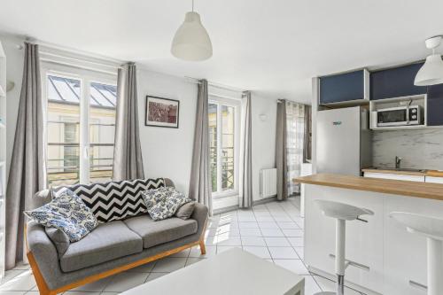 un salon avec un canapé et une cuisine dans l'établissement Ce Rêve Bleu, à Paris