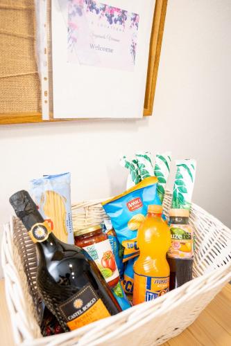 a basket with food and a bottle of champagne at Sognando Varenna-Lake Como View- in Fiumelatte