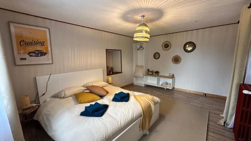 une chambre avec un grand lit blanc avec des oreillers bleus dans l'établissement Domaine Les Fontaines, à Marchésieux