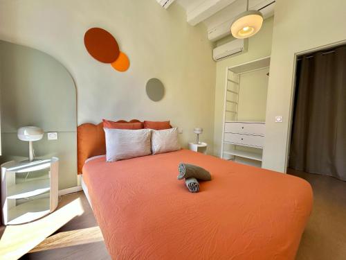 - une chambre avec un lit orange et un miroir dans l'établissement Chez Laura & Thomas - appartement T3 centre ville, proche Vieux Port, Opéra, Place aux Huiles, à Marseille