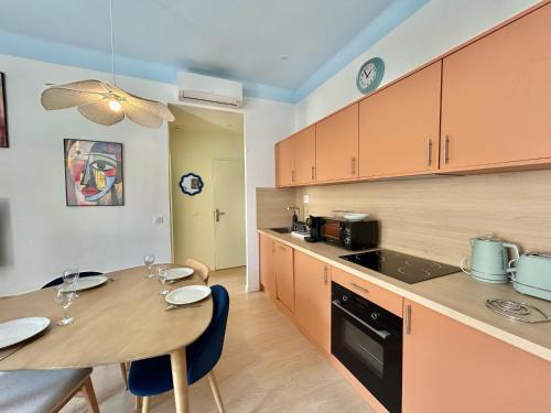 une cuisine avec une table en bois et une salle à manger dans l'établissement Chez Laura & Thomas - appartement T3 centre ville, proche Vieux Port, Opéra, Place aux Huiles, à Marseille