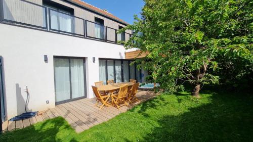 a patio with a wooden table and a tree at Natural Design Lodge Villa Nomade groupe avec jacuzzi centre de Milly la Forêt ! in Milly-la-Forêt