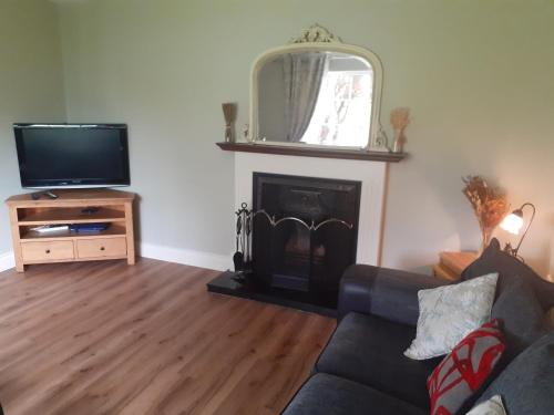 a living room with a couch and a fireplace at Home in Ballina, Ireland in Ballina