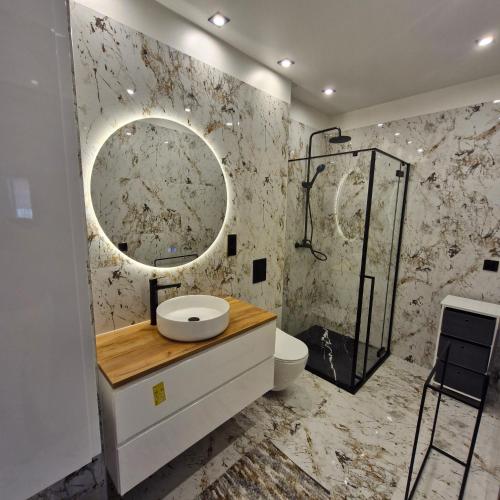 a bathroom with a sink and a shower at Park Miedzywodzie in Międzywodzie