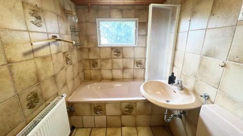 Un baño con bañera, lavabo y ducha. en Zeitwohnen in Hückeswagen -Neu-, en Hückeswagen